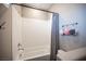 Cozy bathroom featuring a tiled shower-tub combination with modern fixtures and gray shower curtain at 3698 Regatta Landing Dr, Las Vegas, NV 89141