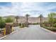 Gated community entrance featuring lush landscaping, stone pillars, and well-maintained road at 3698 Regatta Landing Dr, Las Vegas, NV 89141