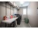 Functional laundry room with modern appliances, ample shelving, and a convenient folding table at 3698 Regatta Landing Dr, Las Vegas, NV 89141