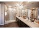 Main bathroom featuring double sinks, a large mirror, a glass-enclosed shower, and modern fixtures at 3698 Regatta Landing Dr, Las Vegas, NV 89141