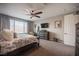 Well-lit main bedroom features a ceiling fan, TV, dresser, and a comfortable armchair near a window at 3698 Regatta Landing Dr, Las Vegas, NV 89141