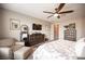 Comfortable main bedroom features a ceiling fan, dresser with TV, mirror, and cozy armchair at 3698 Regatta Landing Dr, Las Vegas, NV 89141