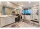 Bright bathroom with double sinks, vanity area, soaking tub, and a glass-enclosed shower with blue accents at 3746 Asia Rd, North Las Vegas, NV 89032