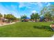 Scenic community park with lush green lawn and a playground with slides under a bright blue sky at 3746 Asia Rd, North Las Vegas, NV 89032