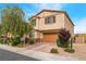 Two-story home featuring a brown two-car garage and a well-manicured lawn with beautiful landscaping at 3746 Asia Rd, North Las Vegas, NV 89032