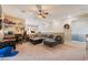 Spacious living room featuring neutral walls, ceiling fan, comfortable seating, and a designated workspace at 3746 Asia Rd, North Las Vegas, NV 89032