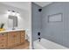 This bathroom features a tub and shower combo with blue tile, with a wood vanity and modern fixtures at 405 Oil Lantern Ln, Las Vegas, NV 89145