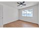 Bright, minimalist bedroom featuring a modern ceiling fan, wood-look floors, and a large window at 405 Oil Lantern Ln, Las Vegas, NV 89145