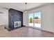Comfortable living area with stone fireplace, patio access, and hardwood floors throughout the house at 405 Oil Lantern Ln, Las Vegas, NV 89145