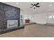 Bright and airy living space with stone fireplace, wood flooring, and open layout to the kitchen at 405 Oil Lantern Ln, Las Vegas, NV 89145