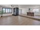 Open-concept living room featuring wood floors, stone fireplace, and kitchen with breakfast bar at 405 Oil Lantern Ln, Las Vegas, NV 89145
