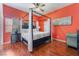 This bedroom features wood floors, a canopy bed, sitting area, and a ceiling fan at 4110 Bonita Desert Ct, North Las Vegas, NV 89032