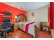 This bedroom has wood floors, red accent wall, and study space at 4110 Bonita Desert Ct, North Las Vegas, NV 89032