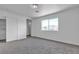A bright bedroom with carpeted floors, a double door closet, and a view of the neighborhood through a window at 4149 Dignified Ct, North Las Vegas, NV 89032