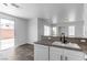 Kitchen area featuring granite countertops, white cabinets and sliding glass door at 4149 Dignified Ct, North Las Vegas, NV 89032
