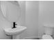 This powder room features a pedestal sink with modern black faucet and white toilet against a neutral wall at 4149 Dignified Ct, North Las Vegas, NV 89032