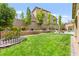 Large backyard with lush lawn, brick retaining wall, and glimpses of a pool and covered patio at 419 Vigo Port St, Las Vegas, NV 89138