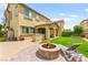Spacious backyard featuring a covered patio, fire pit, lounge chair, and well maintained lawn at 419 Vigo Port St, Las Vegas, NV 89138