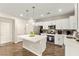 Modern kitchen features white cabinets, stainless appliances, an island, and wood-look floors at 419 Vigo Port St, Las Vegas, NV 89138