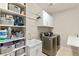 Functional laundry room with shelving, storage baskets, sink, and modern washer/dryer units at 419 Vigo Port St, Las Vegas, NV 89138