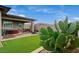 Spacious landscaped backyard with artificial turf, desert plants, decorative stonework, and covered patio at 468 Harvest Rain, Las Vegas, NV 89011
