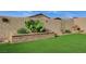 Landscaped backyard featuring artificial turf, desert flora, and block wall perimeter at 468 Harvest Rain, Las Vegas, NV 89011