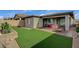 Expansive backyard showcasing artificial turf, tasteful landscaping, a covered patio, and desert flora at 468 Harvest Rain, Las Vegas, NV 89011