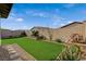 Wide view of well-kept backyard featuring artificial turf, desert landscaping, and a block wall perimeter at 468 Harvest Rain, Las Vegas, NV 89011
