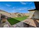 Nicely landscaped backyard features artificial turf, decorative stonework, and a cozy fire pit area at 468 Harvest Rain, Las Vegas, NV 89011