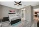 A gray-themed bedroom is brightly lit, shows wood flooring, neutral paint, and flows into the bathroom and kitchen at 468 Harvest Rain, Las Vegas, NV 89011