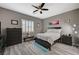 Comfortable bedroom featuring gray wood floors, neutral walls, a ceiling fan, and bright natural light at 468 Harvest Rain, Las Vegas, NV 89011