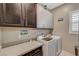 Well-equipped laundry room with modern washer, dryer, gray countertop, and ample cabinet space for storage at 468 Harvest Rain, Las Vegas, NV 89011