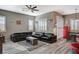 Inviting living room featuring a large black leather sectional sofa, wood floors, and bright windows at 468 Harvest Rain, Las Vegas, NV 89011