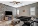 Comfortable living room featuring a large black leather sectional sofa and a decorative stone accent wall at 468 Harvest Rain, Las Vegas, NV 89011