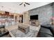 Open living space showcasing the black sectional sofa, kitchen breakfast bar, and decorative stone accent wall at 468 Harvest Rain, Las Vegas, NV 89011