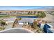Stunning aerial view of the house on a golf course, with desert landscaping, pond, and mountain views at 4924 E Cactus Canyon Dr, Pahrump, NV 89061