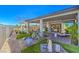 Landscaped backyard with covered patio, artificial turf, mature plants, and stylish outdoor furniture at 4924 E Cactus Canyon Dr, Pahrump, NV 89061