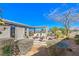 Inviting backyard with a stone patio, pergola, fire pit, and lush landscaping, perfect for outdoor living and entertaining at 4924 E Cactus Canyon Dr, Pahrump, NV 89061