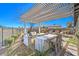 Outdoor kitchen and bar area with seating, a built-in grill, and a stylish pergola at 4924 E Cactus Canyon Dr, Pahrump, NV 89061