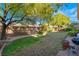 Spacious backyard with mature trees, grass and brick perimeter, perfect for outdoor activities and relaxation at 4996 Del Pueblo Ave, Las Vegas, NV 89141