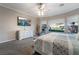 Bright bedroom featuring a ceiling fan, dresser with TV, and windows providing natural light at 4996 Del Pueblo Ave, Las Vegas, NV 89141