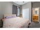 Comfortable bedroom with a floral comforter, carpeted floor, and adjacent bathroom access at 4996 Del Pueblo Ave, Las Vegas, NV 89141