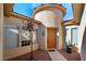 Unique front entryway features a rotunda, manicured landscaping, and a stylish, natural wood front door at 4996 Del Pueblo Ave, Las Vegas, NV 89141