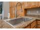 Kitchen featuring a stainless sink, granite countertops, and custom wood cabinetry at 4996 Del Pueblo Ave, Las Vegas, NV 89141