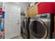Modern laundry room equipped with sleek washer and dryer and storage cabinets at 4996 Del Pueblo Ave, Las Vegas, NV 89141