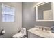 Modern bathroom with white vanity, marble countertop, a modern toilet, and natural lighting from window at 5024 Granite Creek Ct, Las Vegas, NV 89131