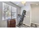 Well-lit exercise area with a treadmill, chest, and window view at 5024 Granite Creek Ct, Las Vegas, NV 89131