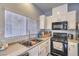 The kitchen offers black appliances, granite countertops, a stainless steel sink, and ample natural light at 5024 Granite Creek Ct, Las Vegas, NV 89131