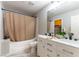 Well-lit bathroom featuring a double vanity, modern fixtures, and a tub-shower combo with neutral colored shower curtain at 509 Chestnut View Pl, Henderson, NV 89052