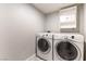 Functional laundry room equipped with a washer, dryer, and overhead storage, offering convenience and organization at 509 Chestnut View Pl, Henderson, NV 89052